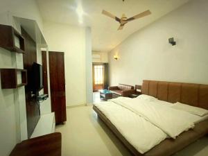 sypialnia z łóżkiem i wentylatorem sufitowym w obiekcie Singanama RESORT w mieście Pachmarhi