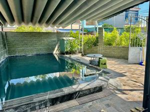 a pool of water with a table in a building at Camy's House in An Bàn (2)