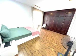 a bedroom with a green bed and a fan at Cozy room close center 671 p41 in Hanoi