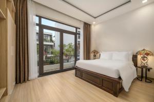a bedroom with a bed and a large window at Tashi Apartment in Da Nang