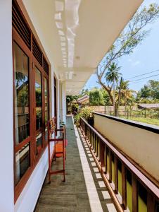 a balcony of a house with a table and chairs at Sea Bay Inn Tangalle in Tangalle