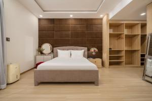 a bedroom with a bed and a wall with shelves at Tashi Apartment in Da Nang