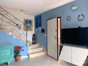 奧羅塞伊的住宿－Seaview Orosei Townhouse by SardiniaGem，一间带大电视和楼梯的客厅