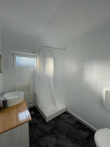 シビウにあるVictoriei Residenceの白いバスルーム(バスタブ、シンク付)
