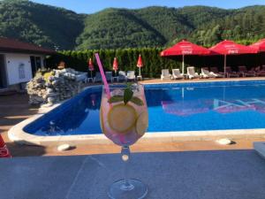 a drink in a glass next to a swimming pool at Комплекс Антик in Troyan
