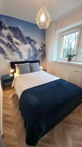 a bedroom with a large bed with mountains on the wall at katedrahouse in Wrocław