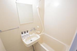 ein weißes Badezimmer mit einem Waschbecken und einem Spiegel in der Unterkunft walk to JR Shibuya sta.-EoE3 in Tokio