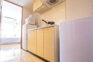 eine Küche mit einem Kühlschrank und einer Mikrowelle in der Unterkunft walk to JR Shibuya sta.-EoE3 in Tokio