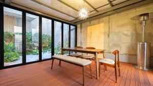 a dining room with a table and chairs and windows at Hotel Schweizer Dorf Cheonan in Cheonan