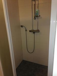 um chuveiro com uma mangueira na casa de banho em two-room apartment midle in Kotka with sauna em Kotka
