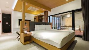 a bedroom with a large bed and a table at Hotel Schweizer Dorf Cheonan in Cheonan