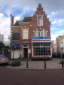 un bâtiment en briques avec un panneau à l'avant dans l'établissement New City Hotel Scheveningen, à Scheveningen