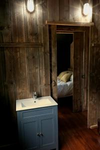 a bathroom with a sink and a bed in a room at Sandringham Safari Tent Lodge in South Creake