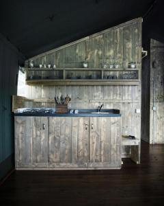 a kitchen with a sink and wooden cabinets at Sandringham Safari Tent Lodge in South Creake