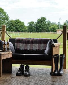 a bench with a blanket and boots on a deck at Sandringham Safari Tent Lodge in South Creake