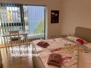 1 dormitorio con cama, mesa y ventana en Wohnen beim Stadtpark en Graz