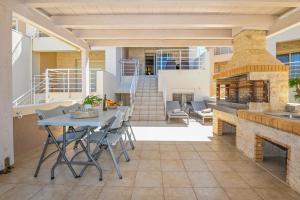 a patio with a table and a fireplace at Sand Lily Residence in Plakias
