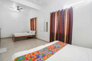 a bedroom with a bed and a window and a table at FabHotel Taj Stay in Agra