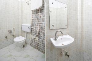 a white bathroom with a toilet and a sink at FabHotel Taj Stay in Agra