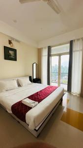 a bedroom with a large bed with a large window at Western Ghats Holiday Home in Kalpetta
