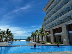 a large swimming pool next to a building at Duy Tân Quảng Bình Hotel & Resort in Dong Hoi