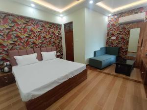 a bedroom with a bed and a blue chair at Hotel O Ramaland Homestay in Ayodhya