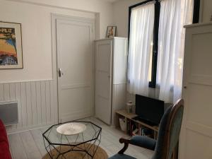 een woonkamer met een tafel en een televisie bij T2 ultracentre au calme Animaux acceptés in Arcachon