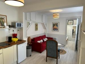 a kitchen and a living room with a red couch at Timounyan T2 centre ville au calme Animaux acceptés in Arcachon