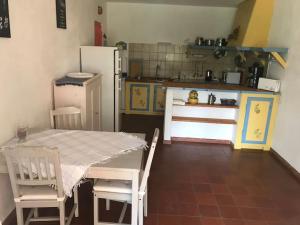 een keuken met een tafel en stoelen en een koelkast bij Maison Provençale avec piscine in Sérignan-du-Comtat