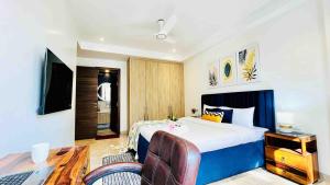 a bedroom with a bed and a desk with a laptop at Olive Service Apartments Saket in New Delhi +20 photos