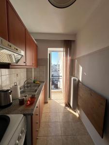 een keuken met een aanrecht en een deur naar een patio bij Rooftop Apartment in Larisa