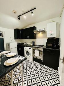 a kitchen with a black and white tile floor at *Super central 20min to Big Ben* in London