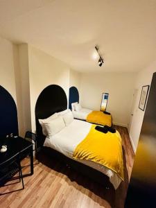 1 dormitorio con 1 cama grande con manta amarilla en *Super central 20min to Big Ben* en Londres