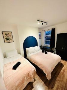 1 dormitorio con 2 camas y ventana en *Super central 20min to Big Ben* en Londres