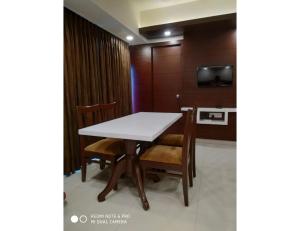 a table and chairs in a room with a tv at Hotel Maurya International, Chennai in Chennai