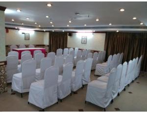 a conference room with white chairs and a table at Hotel Maurya International, Chennai in Chennai