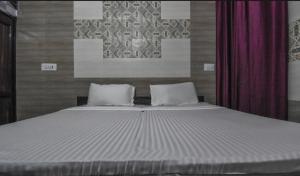 1 dormitorio con 1 cama grande y 2 almohadas en Prince Guest House, en Panchkula