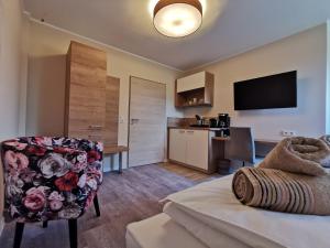 a living room with a chair and a kitchen at Pension Asche in Leese