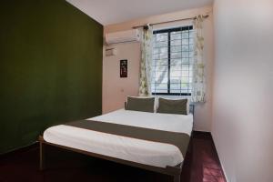 un letto in una camera con parete verde di OYO Collection O Grand Residency ad Auroville