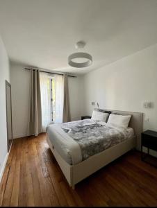 een slaapkamer met een groot bed en een raam bij Somptueux appartement proche stade de france in Enghien-les-Bains