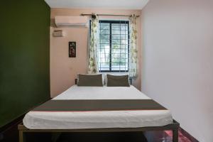 Posto letto in camera con finestra di OYO Collection O Grand Residency ad Auroville