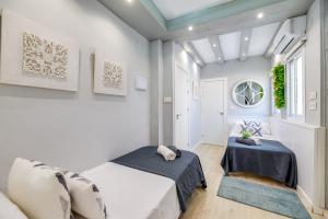 zwei Betten in einem Zimmer mit weißen Wänden in der Unterkunft XPCE Merced Square - PICASSO in Málaga