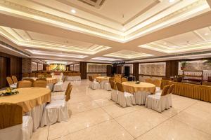 a banquet hall with round tables and chairs at The Elite Lucknow Convention Hotel in Lucknow