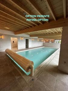 a swimming pool with a bench in a building at Les Arbres sous le vent à 10 min de Pairi Daiza in Jurbise