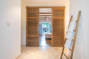 a hallway with wooden doors and a bed in a room at Risemount Premier Resort Da Nang in Da Nang