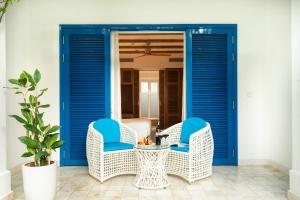 a patio with blue doors and wicker chairs at Risemount Premier Resort Da Nang in Da Nang