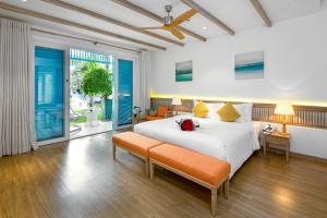 a bedroom with a large white bed and a window at Risemount Premier Resort Da Nang in Da Nang