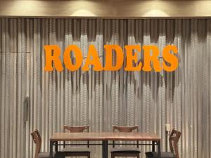 a table with chairs and a sign that reads radios at Roaders Hotel Tainan ChengDa in Tainan