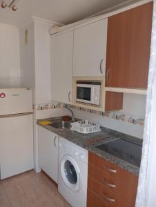 a kitchen with a sink and a washing machine at Piso Loredo in Loredo