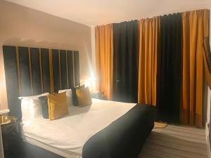 een slaapkamer met een groot bed en gele gordijnen bij *Luxury 9ine Lush Jacuzzi Apartment & Balcony* in Birmingham